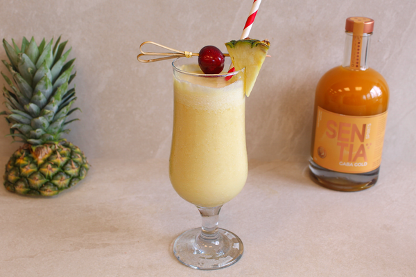 Image of the Pina Colada with a bottle of Sentia GABA Gold and the top of a pineapple in the background